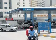  ?? /Reuters ?? Expanding: A man rides a motorcycle near an Adnoc petrol station in Abu Dhabi, United Arab Emirates.