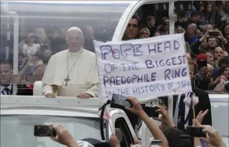  ?? MATT DUNHAM — THE ASSOCIATED PRESS ?? Pope Francis passes by a banner of a protester as he leaves Saturday after visiting St Mary’s Pro-Cathedral in Dublin. The pope faced scattered protests at the start of a two-day visit to Ireland.