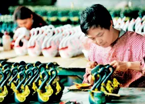  ??  ?? Dans une usine du district de Poyang (province du Jiangxi), des employés peignent des jouets en plastique qui seront exportés vers des pays d’Asie du Sud-Est.