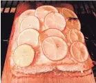  ?? ELIZABETH KARMEL VIA AP ?? This dish of salmon with lemon slices grilled on a cedar plank is from a recipe by Elizabeth Karmel. Recipe on Page 3M.