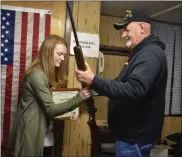  ??  ?? Rachel Champney being handed the rifle she used to achieve her Distinguis­hed Expert title by Marlin “Corky” Rine.