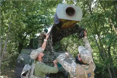  ?? ANATOLII STEPANOV/GETTY-AFP ?? Ukrainian marines from the 37th Brigade install camouflage netting on a M109 155mm self-propelled howitzer at a position in the Donetsk region on July 10.