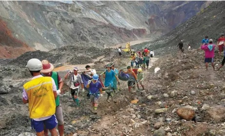  ?? — AFP photo ?? Rescuers recover bodies near the landslide area in the jade mining site in Hpakhant in Kachin state.