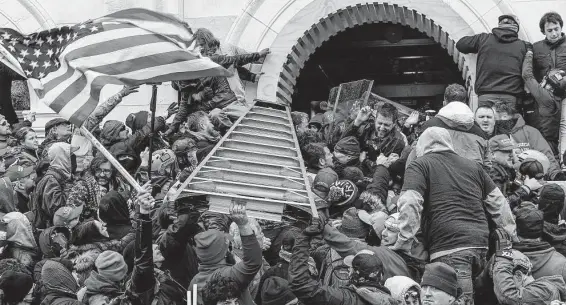  ?? Lev Radin / Tribune News Service ?? Rioters clashing with police use a ladder to try to force entry into the Capitol during the insurrecti­on on Jan. 6 in Washington, D.C.