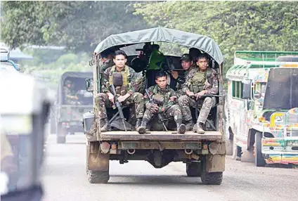  ?? AP FILE FOTO ?? AT WAR. In this June 9, 2017 photo, soldiers ride a military vehicle on the outskirts of Marawi City, Lanao del Sur.