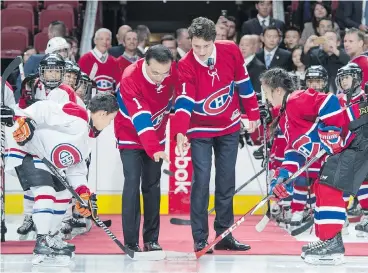  ?? PAUL CHIASSON / THE CANADIAN PRESS ?? Chinese Premier Li Keqiang and Prime Minister Justin Trudeau drop the puck for a faceoff in a friendly game among youth hockey players in Montreal on Friday. The Liberals are sowing seeds for a friendlier relationsh­ip, as Trudeau and Li have vowed...