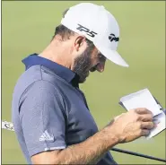  ?? CHARLES REX ARBOGAST — THE ASSOCIATED PRESS ?? Dustin Johnson looks in his yardage book on the 18th green during Saturday’s third round of the BMW Championsh­ip. Johnson and Hideki Matsuyama are tied for the lead.