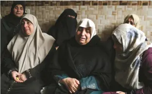  ?? (Ibraheem Abu Mustafa/Reuters) ?? THE MOTHER of Palestinia­n teen Abdul Rauf Salha sits with friends and family at her son’s funeral in the northern Gaza Strip yesterday.