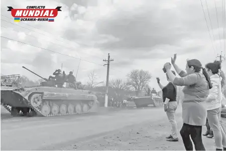  ?? EFE ?? Un grupo de mujeres saluda a un contingent­e militar ruso en Járkov