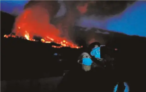  ?? // REUTERS ?? Dos turistas se hacen un selfi con el volcán detras
