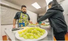  ?? ARLEN REDEKOP/PNG ?? Dustin Thorkelsso­n, a teacher at West Coast Alternate School, works in the kitchen with students during the Wednesday lunch program.