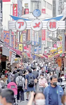  ?? Photo — AFP ?? People wearing face masks walk in a street in Tokyo’s Ueno area two days after the Japanese government lifed a nationwide state of emergency.