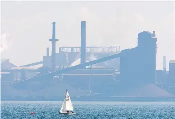  ?? ADRIAN WYLD/THE CANADIAN PRESS FILES ?? A sailboat cruises past the Stelco plant in Hamilton, Ont., in this file photo. Stelco is reportedly seeking to raise about $187 million from an IPO on a potentiall­y $1.25 billion market valuation, months after it emerged from creditor protection.