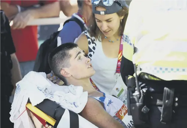  ??  ?? 0 Callum Hawkins receives medical assistance after he collapsed in the men’s marathon less than 2,000m from crossing the finish line on the Gold Coast in Australia