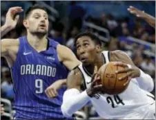  ?? JOHN RAOUX — THE ASSOCIATED PRESS ?? Brooklyn’s Rondae Hollis-Jefferson (24) of Chester looks for a shot against Orlando’s Nikola Vucevic (9) during the second half Tuesday in Orlando, Fla. Orlando won 125-121.