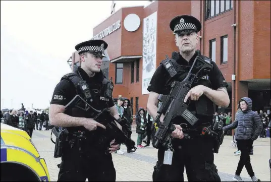  ?? Andrew Milligan The Associated Press ?? Police outside Celtic Park before a soccer match Saturday in Glasgow, Scotland. Hundreds of troops and armed police have been deployed at public sites throughout Britain.