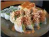  ??  ?? The Clark Roll at Young’s Sushi bar is a busy and delicious mix of deep-fried crab with shrimp, cream cheese, cucumber and avocado that’s topped with a spicy crab salad.