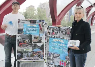  ?? LORRAINE HJALTE/ CALGARY HERALD ?? Michael Bradfield and Deborah Murray hand out postcards Friday calling on the provincial government to act to mitigate the flood threat facing neighbourh­oods and the downtown core.