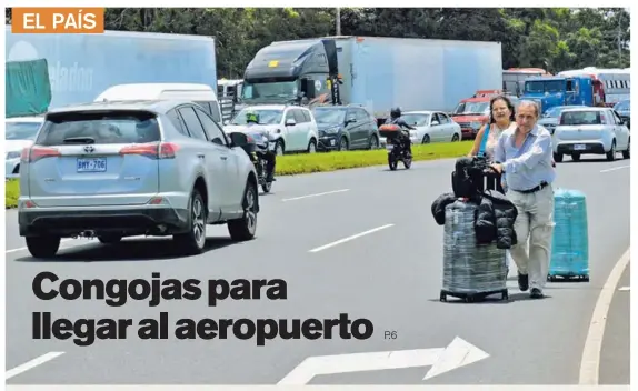  ?? SHIRLEY VÁSQUEZ ?? Una marcha de huelguista­s en el carril San José-Alajuela provocó presas de vehículos y obligó a viajeros que iban al Juan Santamaría a bajarse de los autos y caminar hasta la terminal. Antonio Straing y Silvina Idiviasi, turistas de Argentina, recorriero­n a pie dos kilómetros.