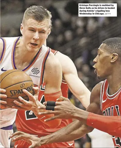  ?? GETTY ?? Kristaps Porzingis is mobbed by three Bulls as he drives to basket during Knicks’ crippling loss Wednesday in Chicago.