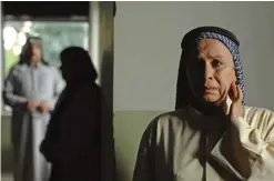  ??  ?? In this still image from the Emirati film "Only Men Go To The Grave", actress Salimeh Yaquob, who plays Arfeh, looks on with concern as her partner's husband comes home.