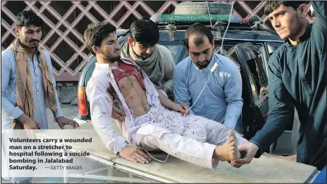  ?? — GETTY IMAGES ?? Volunteers carry a wounded man on a stretcher to hospital following a suicide bombing in Jalalabad Saturday.