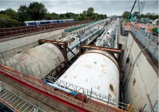  ?? HS2 ?? Caroline, pictured on the right (with sister TBM Sushila, launched on October 6, disappeari­ng undergroun­d to its left), began its own five-mile journey under West London on October 27, excavating the second bore of the HS2 tunnel between West Ruislip and Greenford. A Chiltern Railways Class 165 unit is pictured in the background on the Chiltern Main Line, close to West Ruislip station.