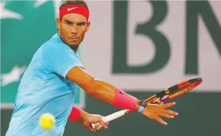  ?? THOMAS SAMSON/AFP VIA GETTY IMAGES ?? Spain's Rafael Nadal returns the ball to Stefano Travaglia during a 6-1, 6-4, 6-0 demolition of his Italian challenger on Friday at the French Open.