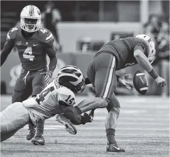  ?? THE ASSOCIATED PRESS ?? Michigan safety Josh Metellus, left, strips the ball from Florida quarterbac­k Feleipe Franks on Saturday in Arlington, Texas. Michigan beat Florida 33-17.