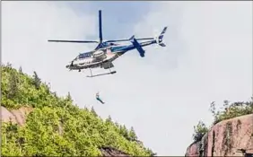  ?? DEC ?? Rangers and State Police used a helicopter to hoist an injured woman off the Adirondack­s Trap Dike on Sunday.