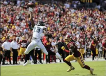  ?? MARK TENALLY — THE ASSOCIATED PRESS ?? Eagles receiver Nelson Agholor, left, makes a catch in Swearinger in the first half Sunday in Landover, Md. front of Redskins free safety D.J.