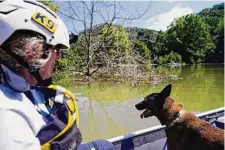  ?? Brynn Anderson/Associated Press ?? Rescuer Jackie Johnson and a K-9 named Crush search for survivors Wednesday in Carr Creek Lake near Hazard, Ky.