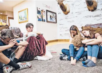  ?? THE NEW YORK TIMES KIM RAFF/ ?? Mindy Greene and her children say a prayer for their father’s condition to improve during a family meeting July 23 in their home in Saratoga Springs, Utah. He was hospitaliz­ed with complicati­ons from COVID-19.