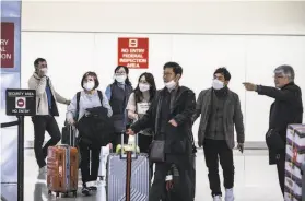  ?? Brian Feulner / Special to The Chronicle ?? Passengers leave the customs area in SFO’s internatin­oal terminal Thursday. Airlines are slashing flights to and from China as the coronaviru­s spreads, and U.S. companies are closing factories and stores.