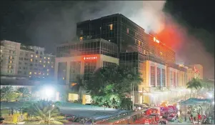  ?? AP PHOTO ?? Smoke rises from the Resorts World Manila complex early Friday in suburban Pasay city southeast of Manila, Philippine­s after gunshots and explosions rang out at the complex.