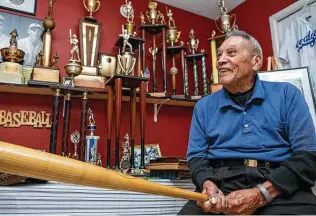  ?? Josie Norris / Staff file photo ?? Willie Doria, then 95, shows the strength still in his wrists as he lifts a bat in the trophy room of friend and former coach Joe Sanchez last November. Doria died July 8 after contractin­g the coronaviru­s. He was known as a home run hitter in the Spanish American Baseball League.