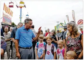  ?? JAY LAPRETE / ASSOCIATED PRESS ?? Gov. John Kasich talks with fairgoers while he tours the Ohio State Fair on Thursday in Columbus. The fair opened, but its amusement rides remained closed one day after Tyler Jarrell, 18, was killed and seven other people were injured when the thrill...