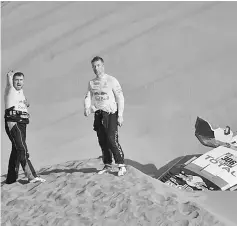  ?? — AFP photo ?? Peugeot’s French driver Sebastien Loeb (right) and co-driver Daniel Elena from Monaco wait after the latter was injured after they ran into sand trouble during the 2018 Dakar Rally Stage 5 between San Juan De Marcona and Arequipa in Peru.