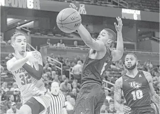  ?? Phelan M. Ebenhack / Associated Press ?? Houston guard Rob Gray, left, whips a pass past Central Florida guard B.J. Taylor during AAC tournament action Friday night. Gray finished with 17 points as the Cougars won 84-56.