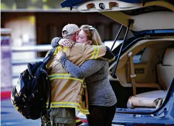  ?? Photos by Billy Calzada / Staff photograph­er ?? Cheryl Anderson embraces her firefighte­r husband, Chris, at San Antonio Internatio­nal Airport as he prepares to board a charter flight to Sacramento, Calif., to help in the fight against wildfires.