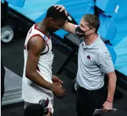 ?? The Associated Press ?? ■ Arkansas head coach Eric Musselman, right, celebrates with guard Davonte Davis after Saturday’s Sweet 16 game against Oral Roberts in the NCAA men’s college basketball tournament at Bankers Life Fieldhouse in Indianapol­is. Arkansas won 72-70.