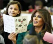  ?? JACQUELYN MARTIN — THE ASSOCIATED PRESS ?? First lady Melania Trump, center, reads Christmas cards written by children of military families, Wednesday during a “Toys for Tots” event at Joint Base Anacostia-Bolling in Washington.