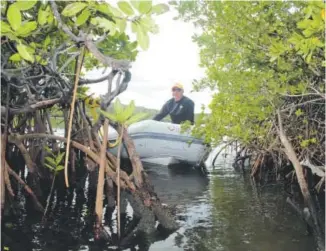  ?? Photos by Scott Elder, The Washington Post ?? The author’s father, Jim, sits in a dinghy at No Name Cay.