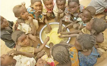  ??  ?? Children eat lunch, often their only meal of the day after school in the village of Intadeyni. Food is provided by Oxfam in an effort to encourage the children to attend school, the challenge to educate children in Mali still exists and particular­ly...