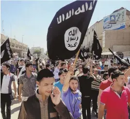  ?? AP FILE PHOTO ?? INCITING FEAR: Demonstrat­ors chant pro-Islamic State slogans as they carry the group’s flags June 16, 2014, in front of the provincial government headquarte­rs in Mosul.
