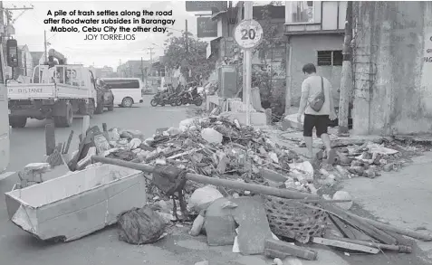  ?? JOY TORREJOS ?? A pile of trash settles along the road after floodwater subsides in Barangay Mabolo, Cebu City the other day.