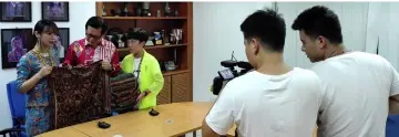  ??  ?? The Guangdong Radio and Television production crew film Lee (centre) as he presents souvenirs to programme host Feng Xueqin and TV personalit­y Zhu Jiayu (right).