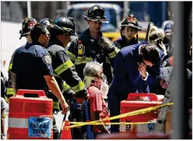  ?? SETH WENIG / ASSOCIATED PRESS ?? Emergency personnel treat a victim after a car plowed through pedestrian­s along three blocks during lunchtime Thursday in New York’s Times Square.