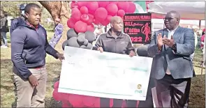  ?? ?? COSPE’s Zama Maziya (L) handing over the E10 000 replica cheque to Minister Moses Vilakati (C) donated towards the event, while Lubombo RA Themba Msibi claps hands in appreciati­on.