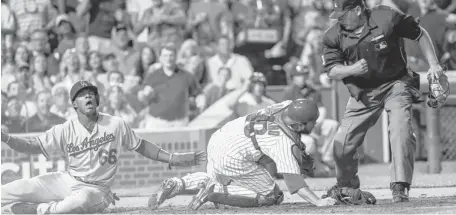  ?? | AP ?? The Dodgers’ Yasiel Puig can’t believe he was tagged out by Cubs catcher Dioner Navarro while trying to score on a single by teammate Adrian Gonzalez in the sixth inning.